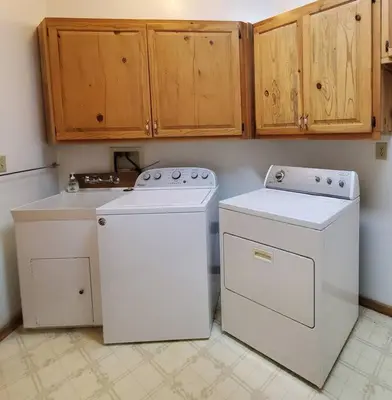 a kitchen with two washing machines and wooden cabinets at Jordan Creek Ranch in Groveland