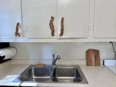 a kitchen with a sink and white cabinets at 1B Heart of the Meadow at The Redwoods In Yosemite in North Wawona
