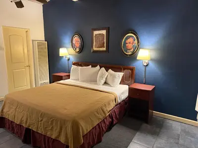 a bedroom with a bed and two pictures on the wall at Cinderella Motel in Hollister