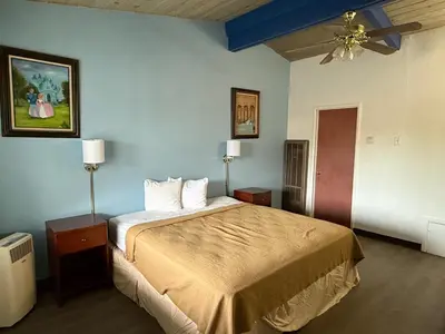 a bedroom with a bed and a ceiling fan at Cinderella Motel in Hollister