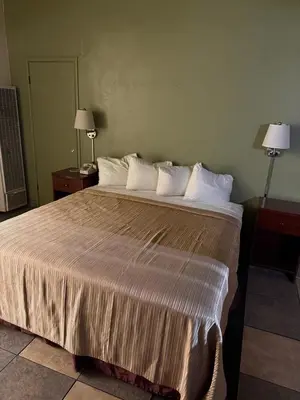 a hotel room with a large bed with white pillows at Cinderella Motel in Hollister