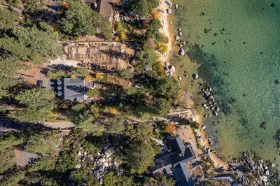 an aerial view of a beach and the water at Spellbound Lakefront Lodge by Tahoe Getaways - 5 BR w Hot Tub, Buoy & Beach access in Kings Beach