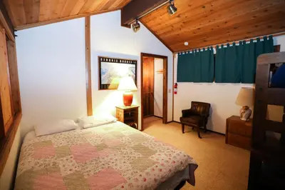 a bedroom with a bed and a chair in it at Updated Mammoth condo on Red line in Mammoth Lakes