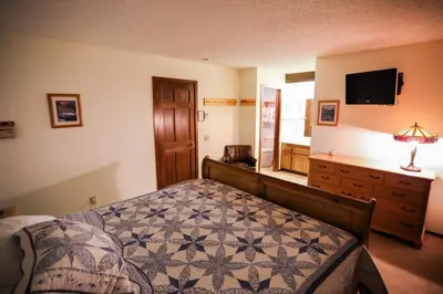 a bedroom with a bed and a dresser and a television at Updated Mammoth condo on Red line in Mammoth Lakes