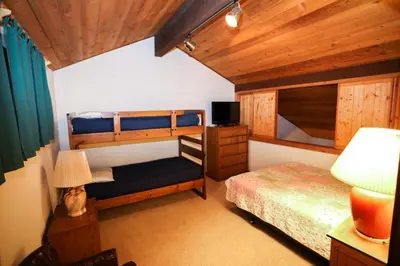 a bedroom with two bunk beds and a lamp at Updated Mammoth condo on Red line in Mammoth Lakes