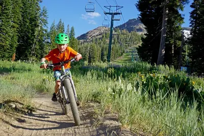 a young boy riding a bike down a trail at Grandeur at Elevation – 3 Bedroom Loft condo in Kirkwood