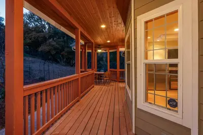 a front porch of a home with a wooden deck at Luxury Lodge-Hot Tub-BBQ-Sleeps 18 in Oakhurst
