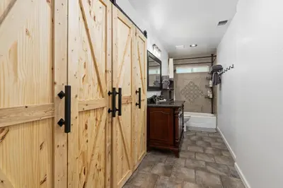 a bathroom with wooden sliding doors and a tub at 4000 SF, 20 Acre Gated Luxe Estate, Game Room, Pano View, Pool, Spa in Coarsegold