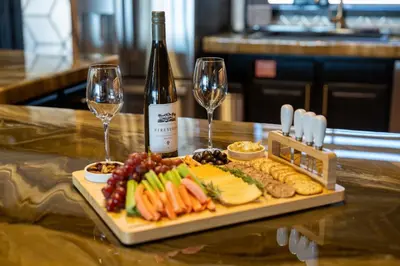 a plate of food and two wine glasses on a table at 4000 SF, 20 Acre Gated Luxe Estate, Game Room, Pano View, Pool, Spa in Coarsegold