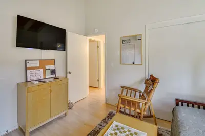 a living room with a bed and a television on a wall at Deck and Fire Pit Pine Mountain Lake Getaway! in Groveland