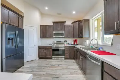 a kitchen with wooden cabinets and stainless steel appliances at On-Site Winery Rural Plymouth Getaway! in Plymouth