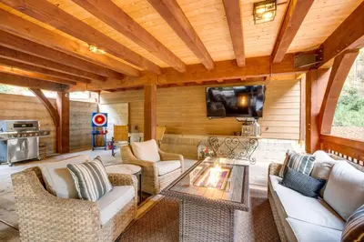 a living room with a couch and a table and a tv at Bear Lodge Waterfront Cabin with Level 2 EV Charger in Sutter Creek