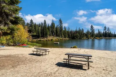 two picnic tables on a beach next to a lake at Well Kept Condo CS#3 - Pets OK in Bear Valley