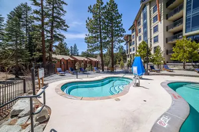 a swimming pool with chairs and a building at Updated Pet Friendly Monache Studio with Views! in Mammoth Lakes