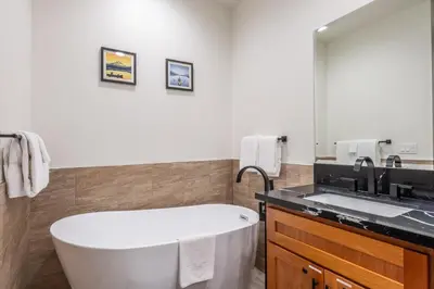 a bathroom with a bath tub and a sink at Obsidian 210 in Mammoth Lakes