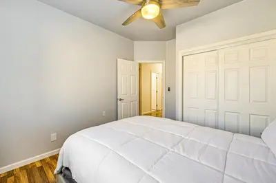 a bedroom with a white bed and a ceiling fan at 26 Mi to Fresno Pet-Friendly Home in Reedley! in Reedley