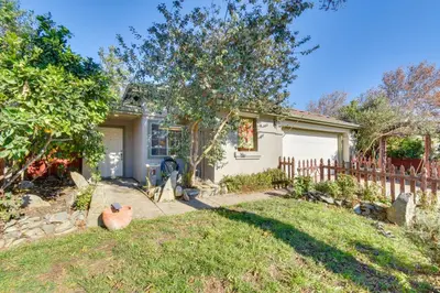 a white house with a fence and a yard at 4 Mi to San Joaquin River Peaceful Patterson Home in Patterson