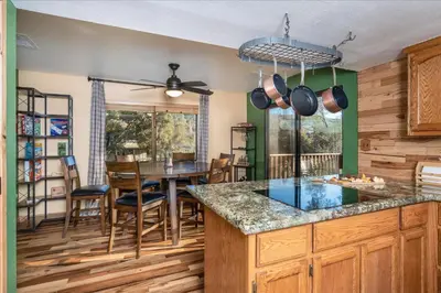 a kitchen with a table and a dining room at Sequoia's Dream with Mountain View, Spa, Heated Floor, Bar, Cinema! in Oakhurst