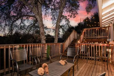 a deck with chairs and a table and a staircase at Sequoia's Dream with Mountain View, Spa, Heated Floor, Bar, Cinema! in Oakhurst