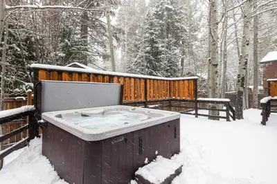 a hot tub in the snow next to a fence at Cabin for 8 HotTub Close to Ski Town Private Beach in Tahoe City