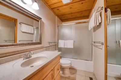 a bathroom with a sink and a toilet and a mirror at Wanderlust Retreat by Tahoe Getaways - 4BR Pet-Friendly w Fenced Yard, Walking Distance to Lake! in Tahoe City