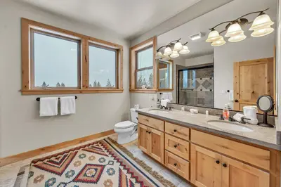 a bathroom with a sink and a toilet and windows at Spacious Tahoma Retreat with Hot Tub and Game Room in Tahoma