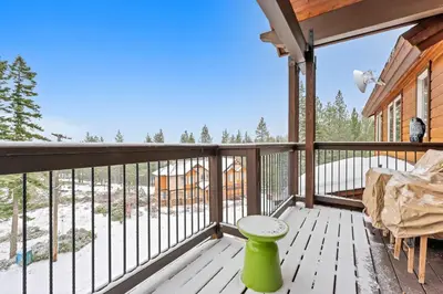 a balcony of a cabin with a table and a chair at Spacious Tahoma Retreat with Hot Tub and Game Room in Tahoma
