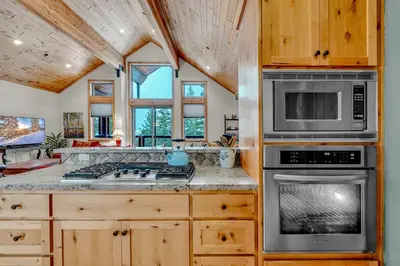 a kitchen with a stove and a microwave at Spacious Tahoma Retreat with Hot Tub and Game Room in Tahoma