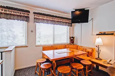 a dining room with a table and chairs and a television at Alpine View in Yosemite West