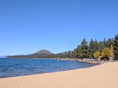 a view of a beach with trees and water at 3987 - Upscale Townhouse Walk to Heavenly, Casino and Beach in South Lake Tahoe