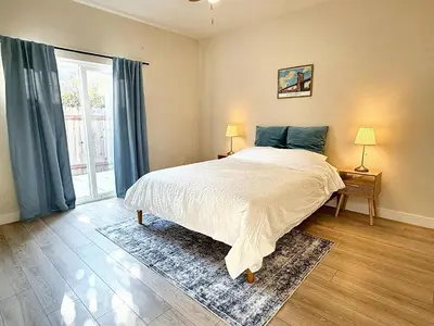 a bedroom with a bed and a large window at 5 Min Walk to UCD Med Ctr - Stylish New Build Home in Sacramento