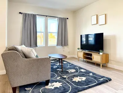 a living room with a couch and a tv at 5 Min Walk to UCD Med Ctr - Stylish New Build Home in Sacramento