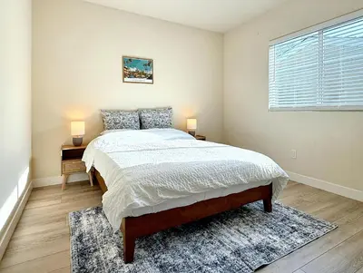 a bedroom with a bed and two lamps on tables at 5 Min Walk to UCD Med Ctr - Stylish New Build Home in Sacramento