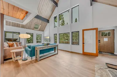 a living room with a blue couch and a table at Tahoe City Vacation Rental with Fireplace and Deck in Tahoe City