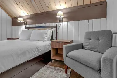 a bedroom with a bed and a chair at Tahoe City Vacation Rental with Fireplace and Deck in Tahoe City