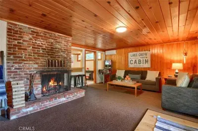 a living room with a brick fireplace in a house at Lake View Cabin Private Dock Free Night Special in Bass Lake