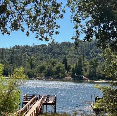 a wooden bridge over a body of water at Lake View Cabin Private Dock Free Night Special in Bass Lake