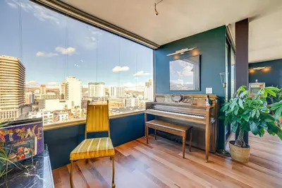 a room with a piano and a chair in front of a window at Luxe Dtwn Reno Penthouse about 3 Mi to Casinos! in Reno