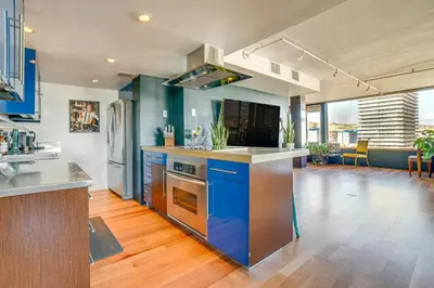 an open kitchen with blue cabinets and blue appliances at Luxe Dtwn Reno Penthouse about 3 Mi to Casinos! in Reno