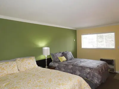 a green room with two beds and a window at Tea Garden Lodge in South Lake Tahoe