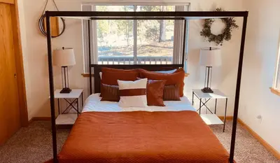 a bedroom with an orange canopy bed with pillows at Shaver Lake, 4 BDR HOT TUB Misty Mountain Retreat in Shaver Lake