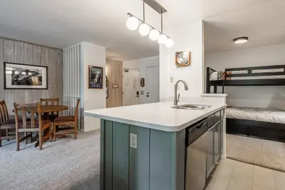 a kitchen and living room with a sink and a bed at Crestview #3 bldg C 1 Bedroom plus Den / 2 Bathroom, close to town shuttle and short walk to village in Mammoth Lakes