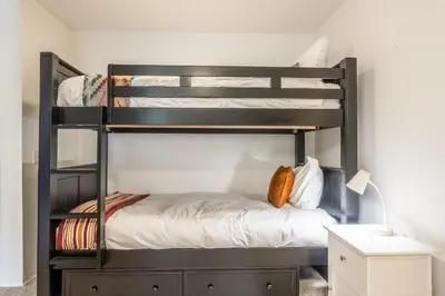a black bunk bed in a room with a desk at Crestview #3 bldg C 1 Bedroom plus Den / 2 Bathroom, close to town shuttle and short walk to village in Mammoth Lakes