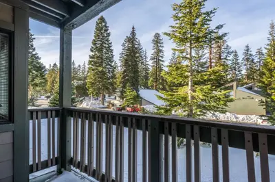 a balcony with a view of snow covered trees at Crestview #3 bldg C 1 Bedroom plus Den / 2 Bathroom, close to town shuttle and short walk to village in Mammoth Lakes