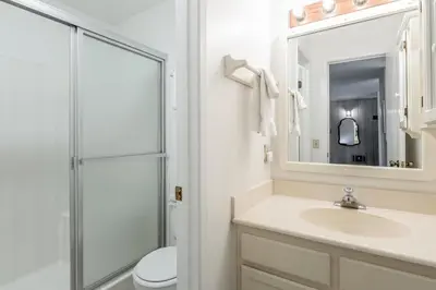 a white bathroom with a sink and a shower at Crestview #3 bldg C 1 Bedroom plus Den / 2 Bathroom, close to town shuttle and short walk to village in Mammoth Lakes
