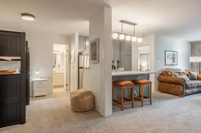 a living room with a kitchen and a couch at Crestview #3 bldg C 1 Bedroom plus Den / 2 Bathroom, close to town shuttle and short walk to village in Mammoth Lakes