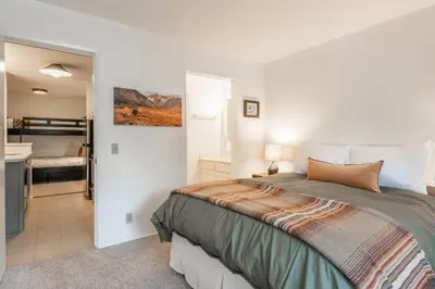 a bedroom with a bed and a bathroom at Crestview #3 bldg C 1 Bedroom plus Den / 2 Bathroom, close to town shuttle and short walk to village in Mammoth Lakes