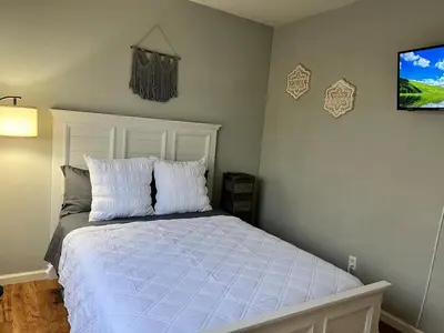 a bedroom with a bed with white sheets and a tv at Cozy House in Fallon- 3BedRoom, 2BathRooms in Fallon