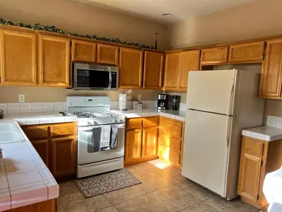 a kitchen with a white refrigerator and wooden cabinets at Cozy House in Fallon- 3BedRoom, 2BathRooms in Fallon