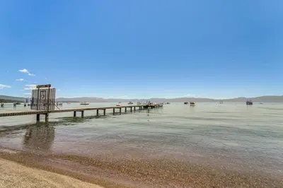a beach with a pier in the water at Less Than 2 Blocks to Lake Tahoe Family Home Near Skiing in Homewood